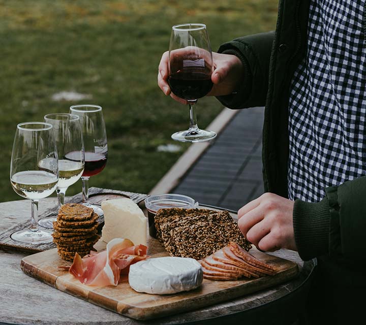 Man holding wine and selecting cheese